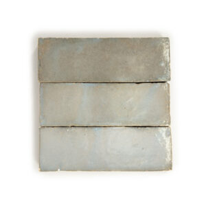 A white tile with three different colors of tiles.